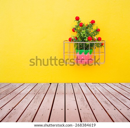 Fake ornamental plants with concrete wall and wood floor.