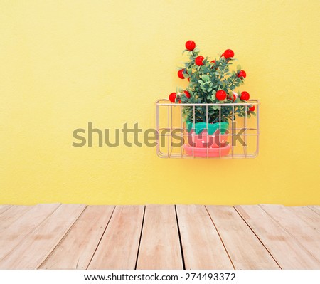 Fake ornamental plants with concrete wall and wood floor, vintage color tone.