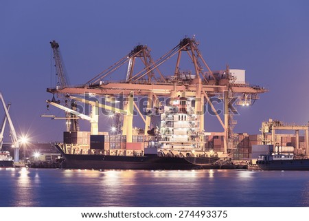 Cargo ship and crane at port, purple color tone.