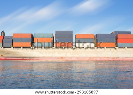 Cargo ship and cargo container in sea with clear sky background.