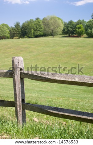 Wood Split Rail Fence with Grassy Landscape Background