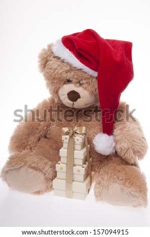 Christmas teddy bear in Santa Hat and pile of Christmas presents, isolated on white background