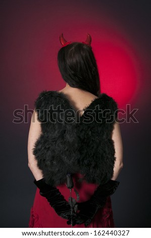 Halloween devil with black wings, and a black rose, on dark background
