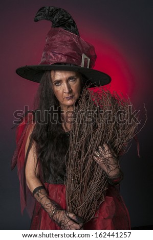Halloween witch with broomstick on dark background