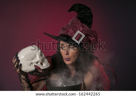 Halloween witch casting spells, with skull and cauldron on dark background