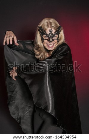 woman dressed as Halloween vampire bat isolated on dark background