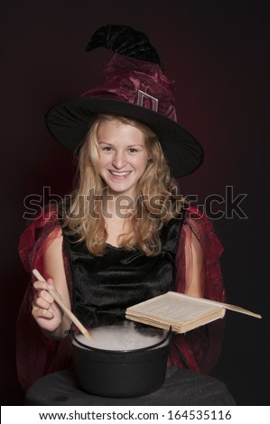 beautiful Halloween witch isolated on dark red background