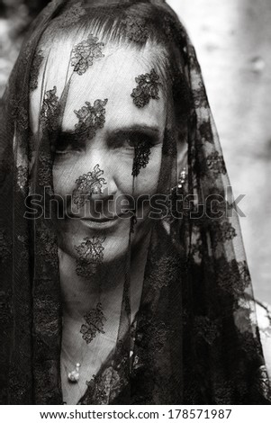 widow in mourning with veil over her face in monochrome