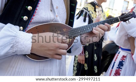 Musician playing mandolin on the street. Musician recital giving abroad. Closeup of a mandolin. Mariachi brightening event.