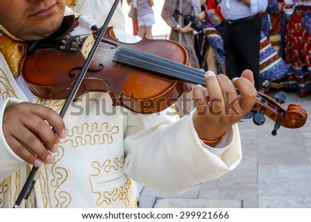 Musician playing violin in the streets. Giving concert violinist abroad. Closeup of a violin. Mariachi brightening event.