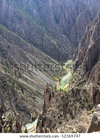 View of Black Canyon of the Gunnison Colorado Rugged Cliffs and River. Steep cliffs above the Gunnison River rugged rocky canyon. Scenic landscape looking down.