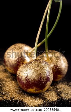 Gold fruits on black background close up