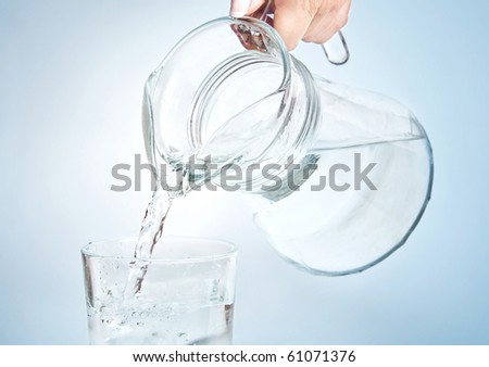 Pouring water into the glass from jug
