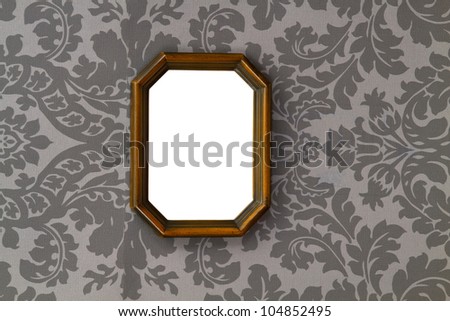 Blank vintage wooden picture frame on ornamental wallpaper