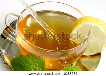 Lemon balm tea in a glass cup with garnish on light background