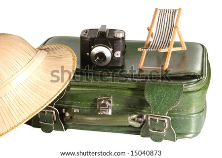 Old suitcase with safari hat and little deck chair on light background