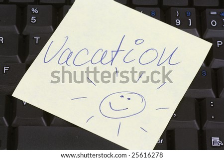 Yellow post it paper on a keyboard with message vacation