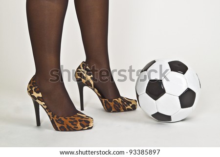Sexy woman foot with high heels and soccer ball on white background