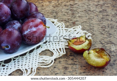 ripe wet plum lies in a white plate