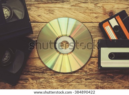 video tapes, audio tapes and compact disc on a wooden table