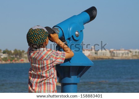 boy looking through a telescope