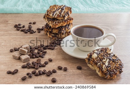cup of coffee with biscuits, sugar and grains of coffee