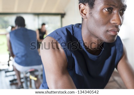 two Friends Are In A Spinning Class At Gym. Fitness coach and two friends at a exercise bike class