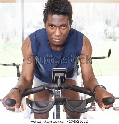 young black man riding an exercise bike
