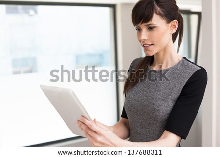 Working with a tablet is much easier. Portrait of smiling young business woman holding digital tablet