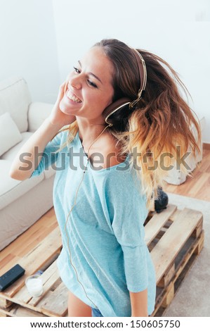 Happy Girl Dancing At Home While Listen Music With Headphones. She Is In Her Home