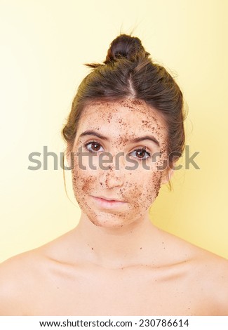 Brunette woman with a scrub applied in her face