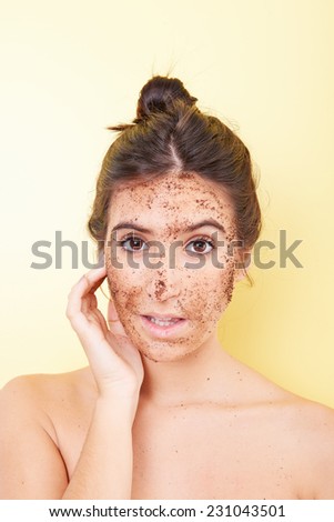 Brunette woman with a scrub applied on her face