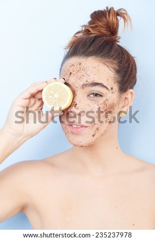 Red-haired woman with a scrub applied  and a slice of lemon