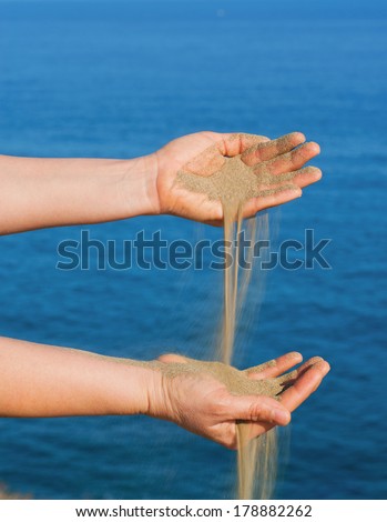 Hand pouring sand