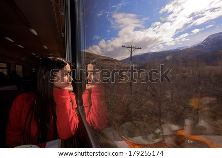Young girl looking through train window.