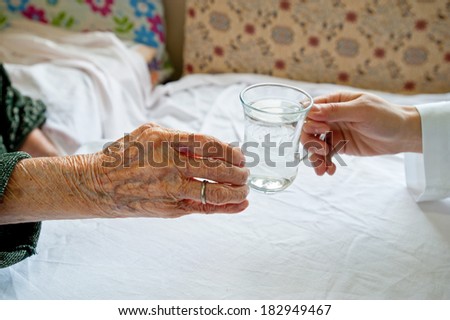 Helping hand. Nurse helping elderly woman