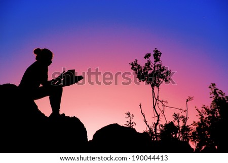 A silhouette of a Cute girl reading a book