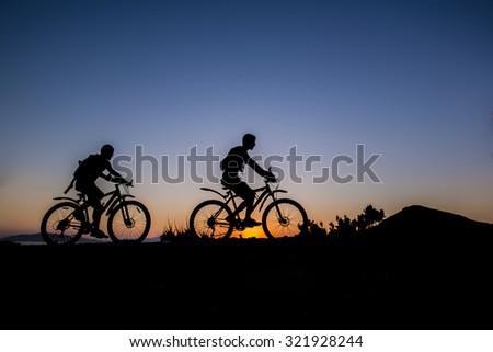 Silhouette of a men  on mountain bike at sunset