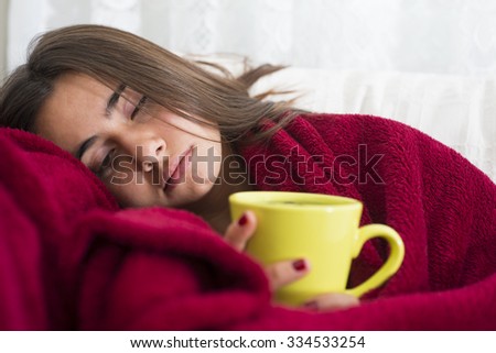 ill young girl with fever drinking cup of warm tea