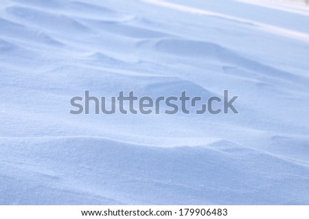 Abstract detail of drifting snow catching early morning light showing gentle ridges with subtle highlights and shadow