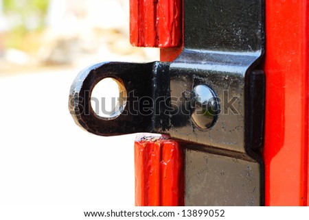 The part of a red door with an iron  ear for the padlock - can be used as an abstract background. Close-up