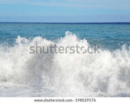 Big wave with sea foam and blue water. Beach Splashing Waves. Summer background.