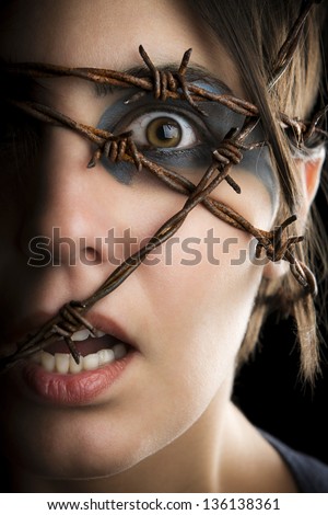 Terrified woman with barbed wire around the head.