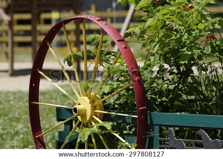 Old red wooden wagon wheel, farm house