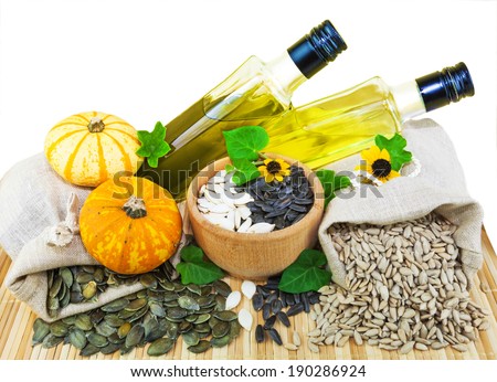 Macro view of raw sunflower seeds and pumpkin seeds in flax sacks and sunflower and pumpkin oil isolated on white background