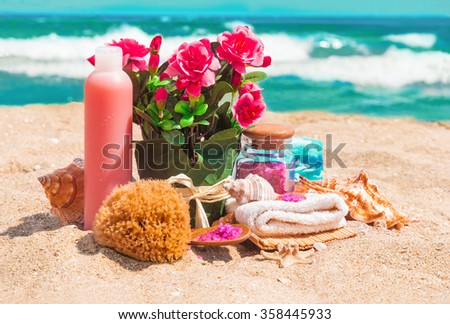 Macro view of spa beauty products: towels, soap, shells, sea salt and pink flowers roses in the flowerpot on the sea coast