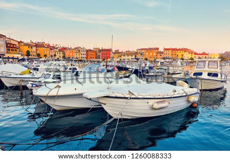 Rovinj, Croatia. Motorboats and boats on water in port of Rovinj. Medieval vintage houses of old town. Yachts landing, tower with clock. Morning sunrise blue sky withclouds.