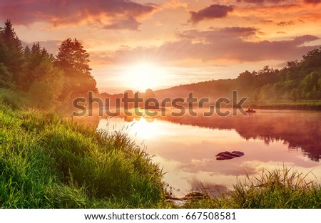 Landscape with sunset on the lake. Matutinal picturesque morning sky clouds in water sunbeam forest.