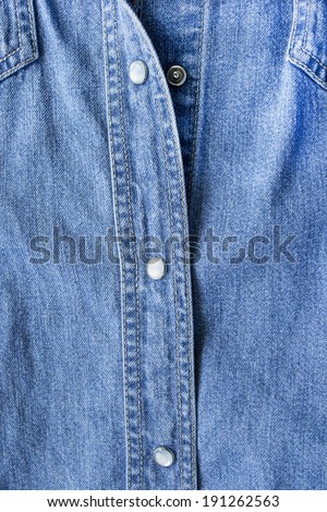 Element of buttoned blue denim jacket closeup