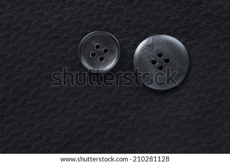 Black cloth with pair of black plastic buttons